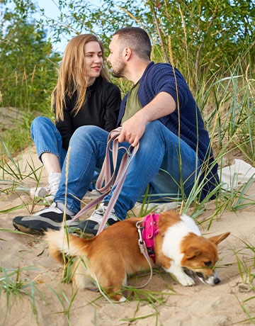 husband wife on the beach with their Corgi sober happily married in recovery