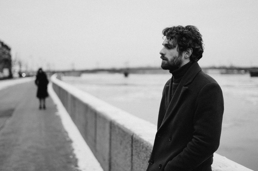 What Length of Time Is Needed for Addiction Recovery to Work? 3 Black and white photo of a man who is patiently waiting