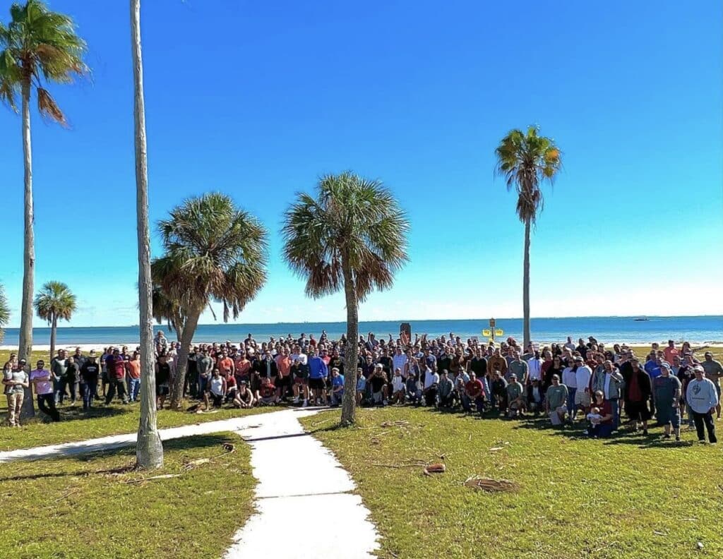 sober living event with a large group of people at a park by the beach