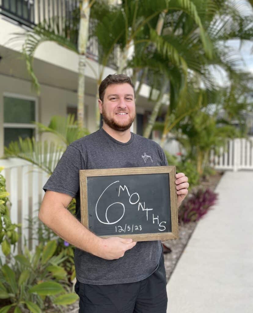 man holding 6 months sober chalkboard in Tampa
